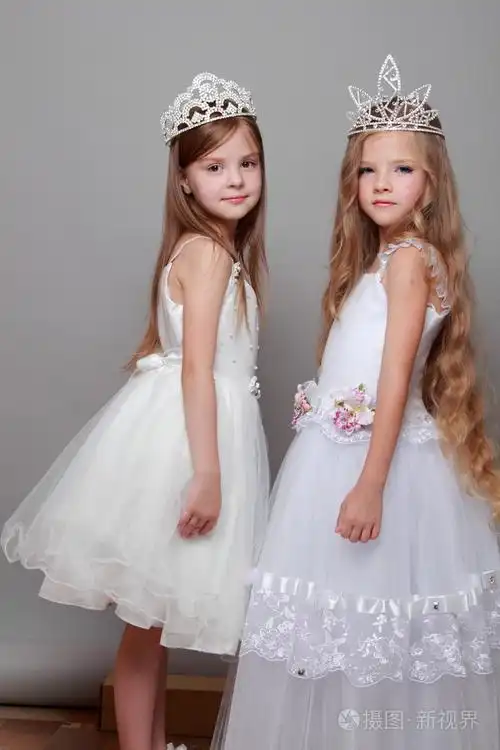 迷人和优雅的小女孩身穿白衣头戴皇冠的美丽和时尚