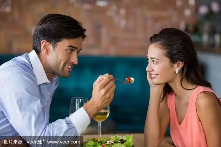 微笑的男人给女人喂饭
