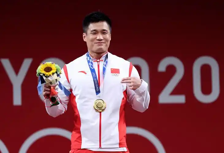吕小军在东京奥运会举重男子81公斤级颁奖仪式上庆祝.