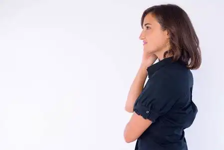 手托下巴思考的美女侧面图照片