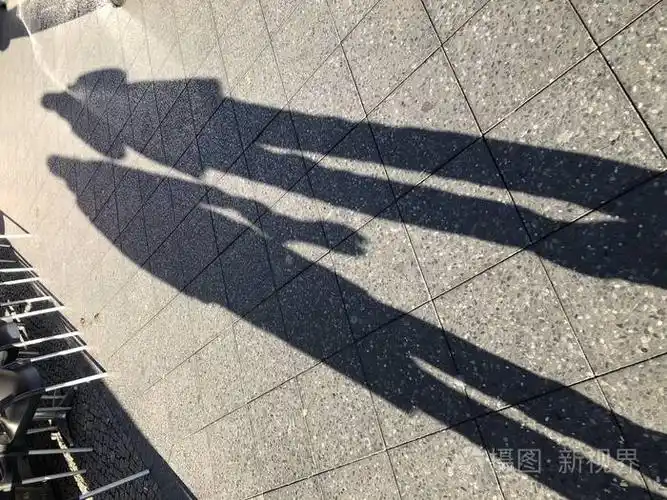 人行道上两个人的长长的影子明亮的黄昏太阳