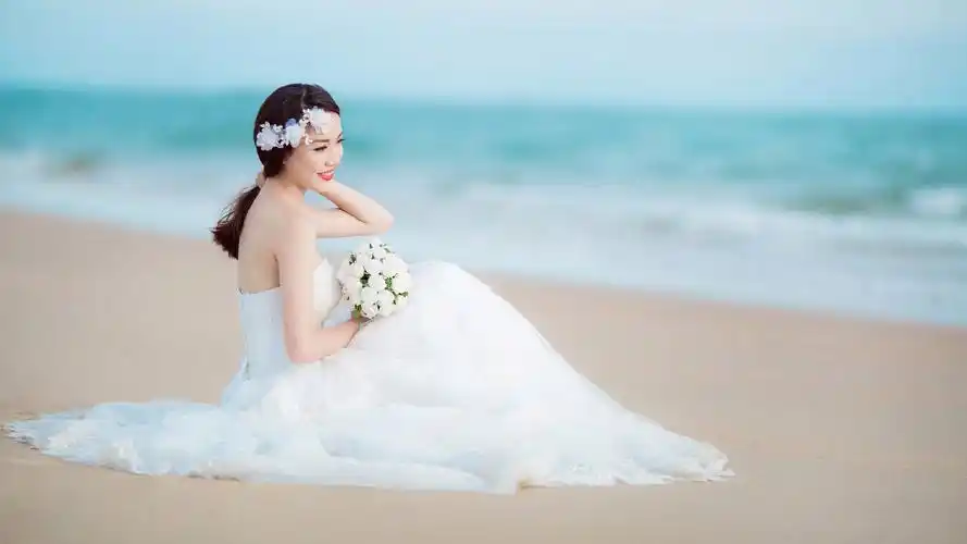 新娘微笑倩影,婚纱礼服配鲜花,沙滩大海映美照,美女婚纱照壁纸免费