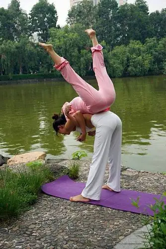 瑜伽双人配合高难度的动作,可以让女人的形体变成艺术自然之美.