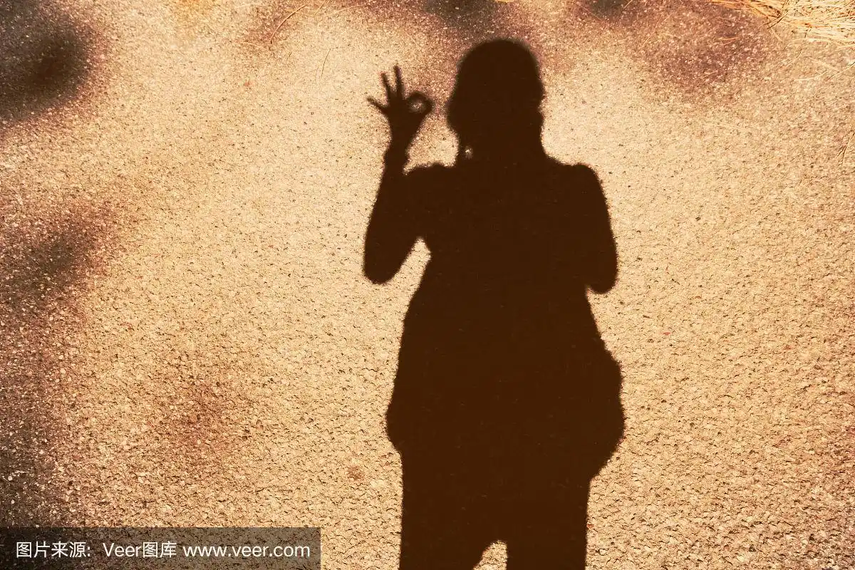 一个年轻女孩的影子用ok手势的背景,手ok手势的背景概念一切ok.