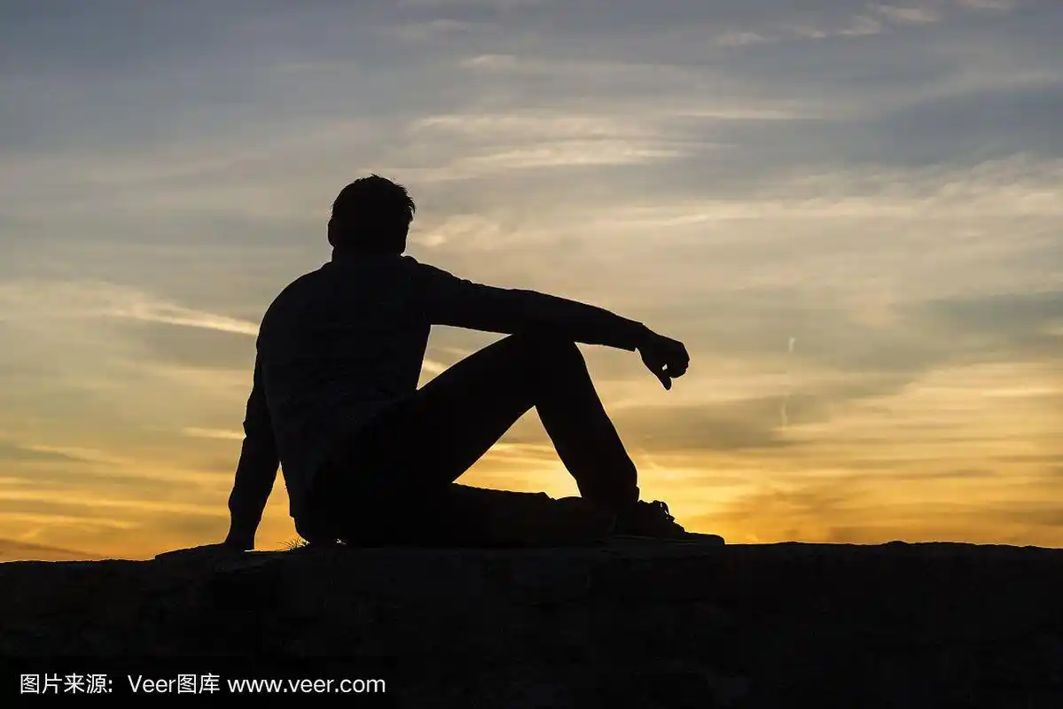 夕阳下一个坐着的男人的剪影