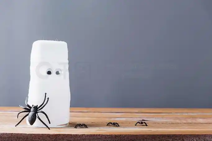 有趣的工艺品万圣节日装饰派对,特写木乃伊来自水玻璃和蜘蛛,用绷带