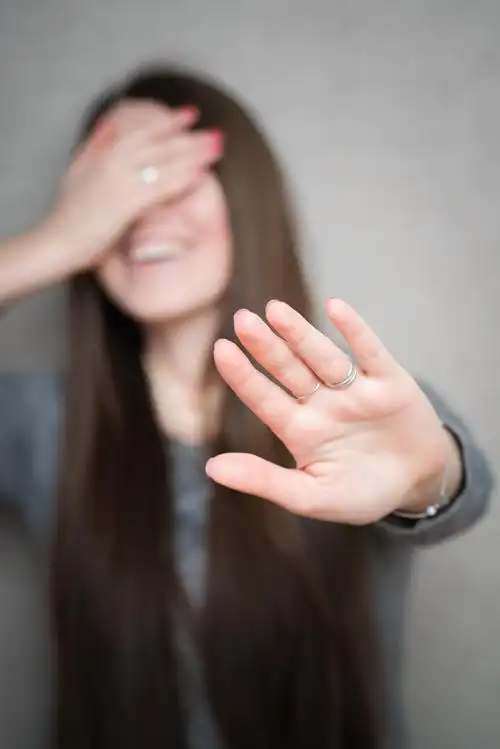 年轻的黑发女人笑着捂着脸