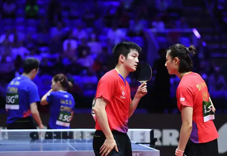 4月25日,樊振东(右二)/丁宁(右一)在比赛中交流战术.