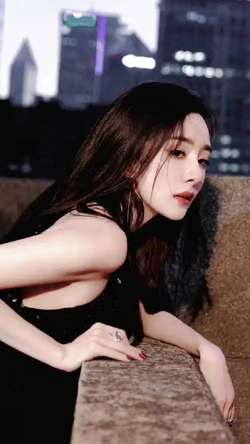 杨幂身穿黑色吊带露背连衣裙,俏脸成熟妩媚,背身靠墙的样子很销魂 –