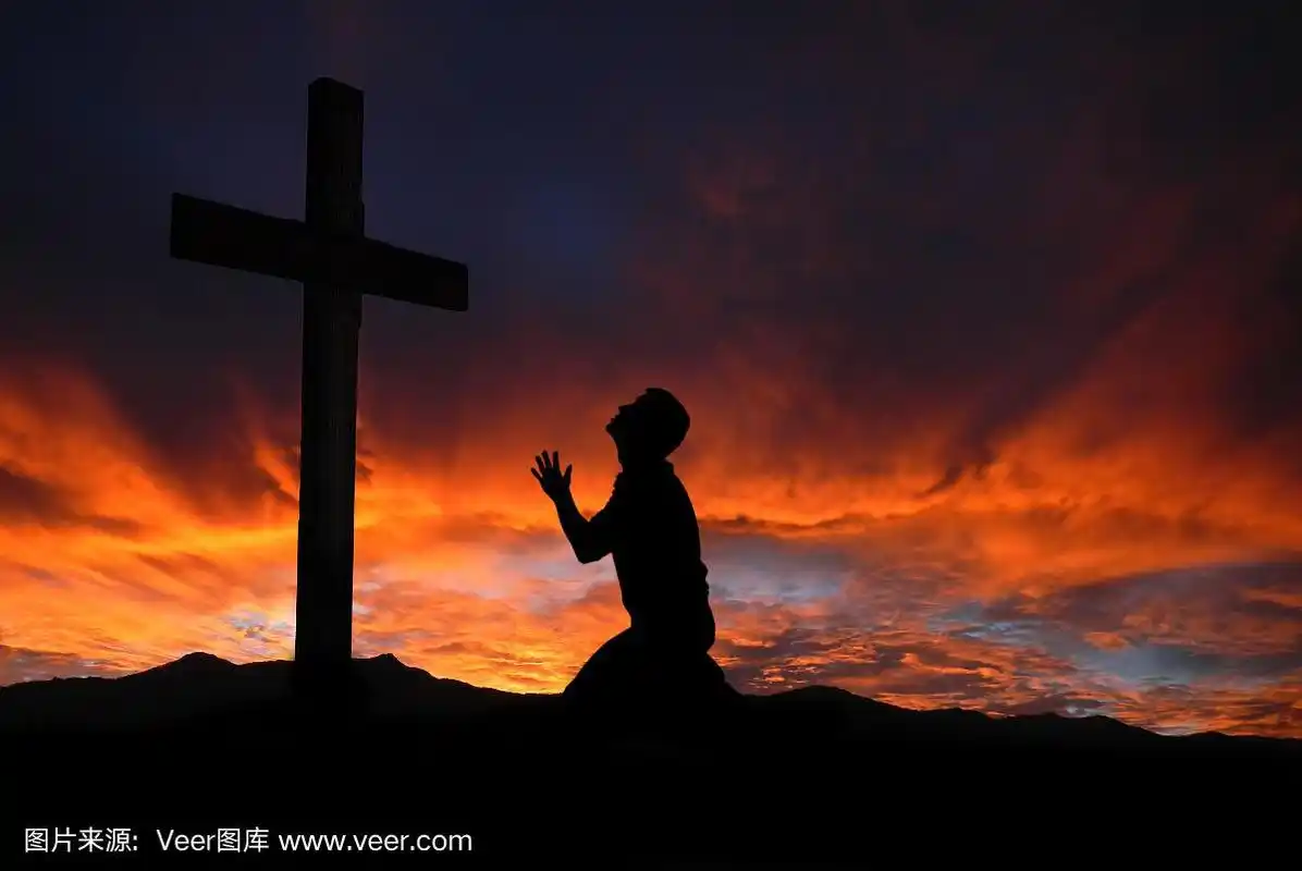 一个人的剪影祈祷一个十字架与天上的云景观