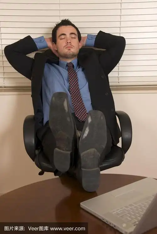 一个翘着脚坐在办公桌前休息的商人