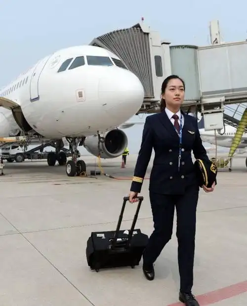 在安徽合肥,民航飞行员顾新悦从飞机前经过.