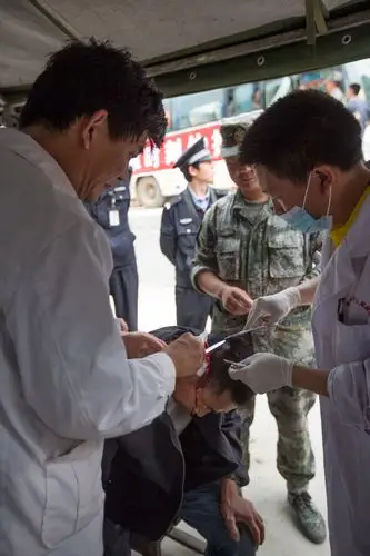 医生正为一位头部受伤的灾民包扎伤口.