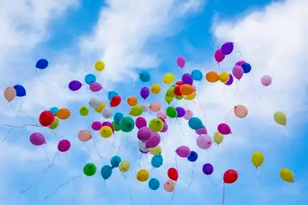 五颜六色的气球在天上飞了照片