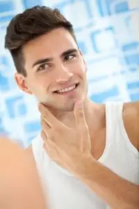 男人看起来自己在浴室里的镜子照片