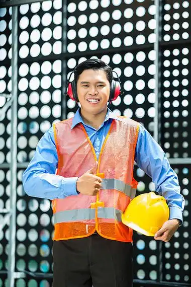 亚洲建筑工地戴头盔和安全背心的亚裔印尼建筑工人