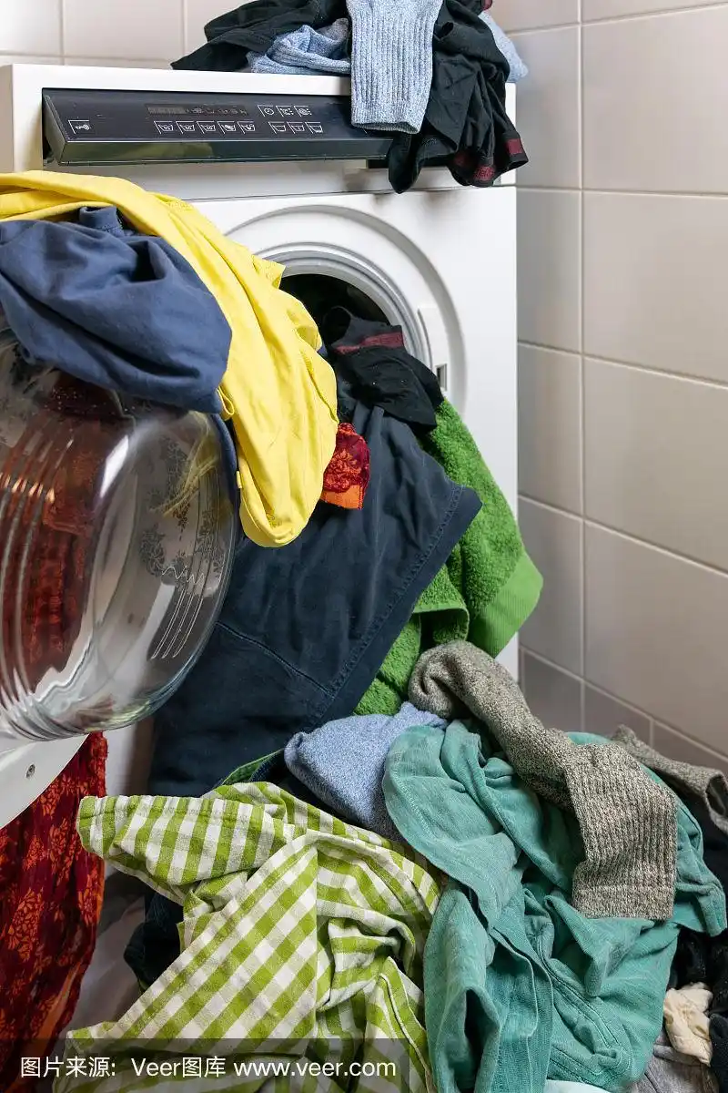 一大堆五颜六色的脏衣服洗衣机里塞满了衣服