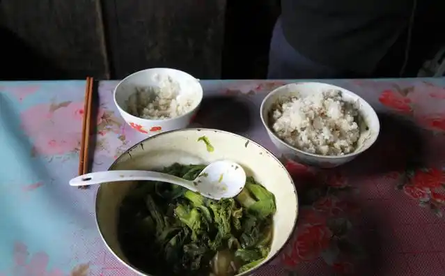 男主人站在自家门口,墙上的"寿比南山不老,福如东海长流"语句依稀