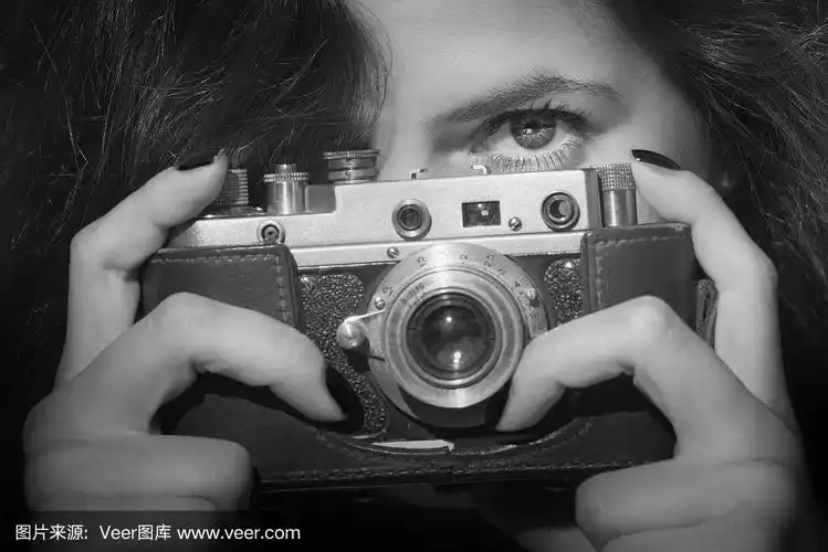 带着复古相机的年轻女子.黑白照片