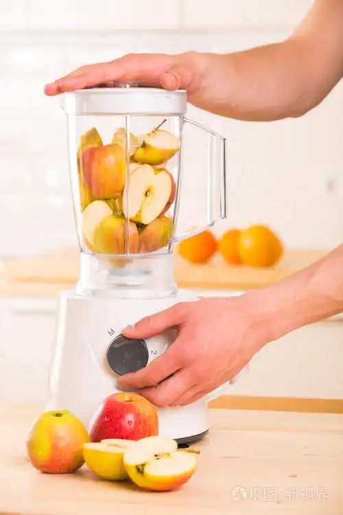 白色搅拌机用木制的桌子上的苹果