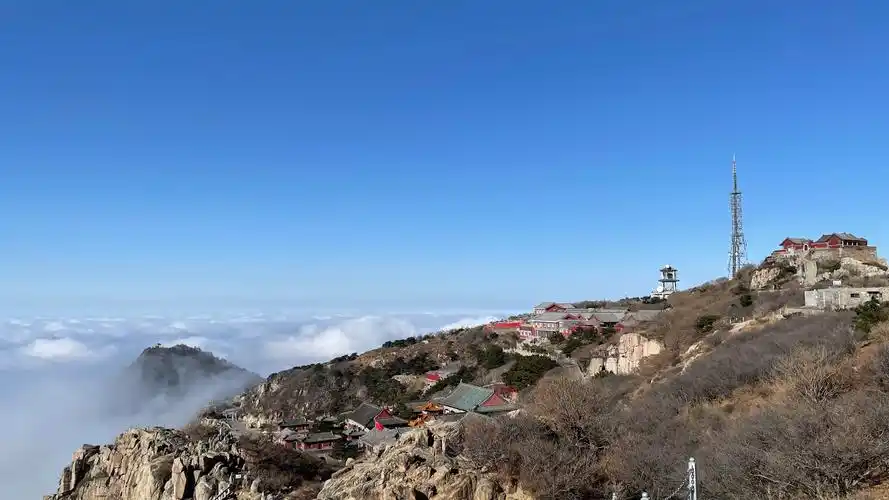 阳光倾泻而下,透过云海在泰山上投射出光影的变幻.