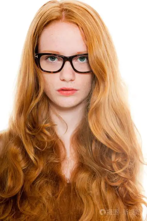 穿棕色衬衫和复古眼镜长红头发的漂亮女孩时装工作室射上孤立的白色