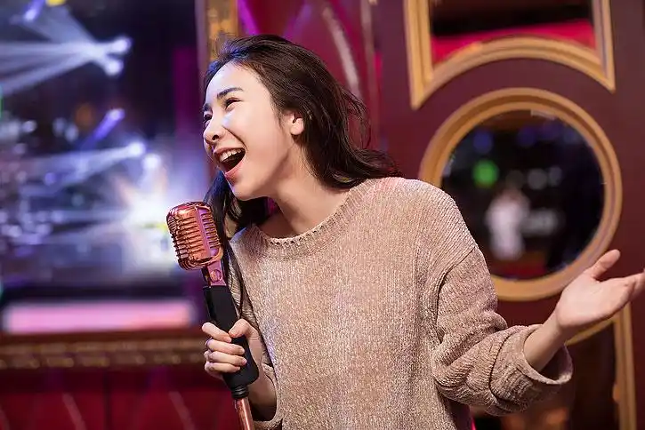 快乐的年轻女士在ktv唱歌