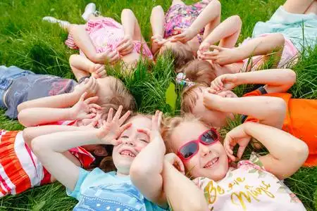 一群孩子在公园里的草地上玩耍和奔跑照片