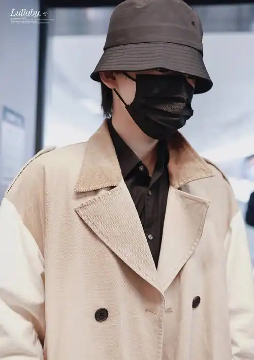 少年团-宋亚轩现身机场,身穿卡其色风衣内搭黑衬衫,头戴黑色渔夫帽压