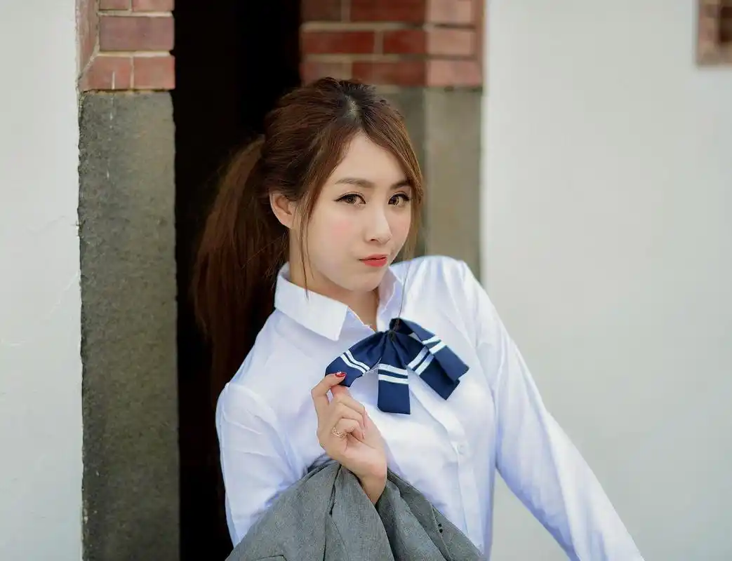 身穿校服的一位淘气大方的小姐姐,迷人的样子让我不自觉地想到了高中