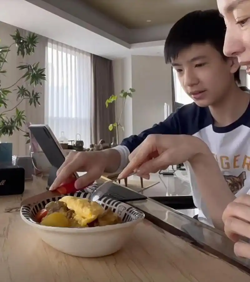 潘粤明儿子顶顶在家玩平板,董洁为孩子做蛋包饭,脸很小但五官比较端正