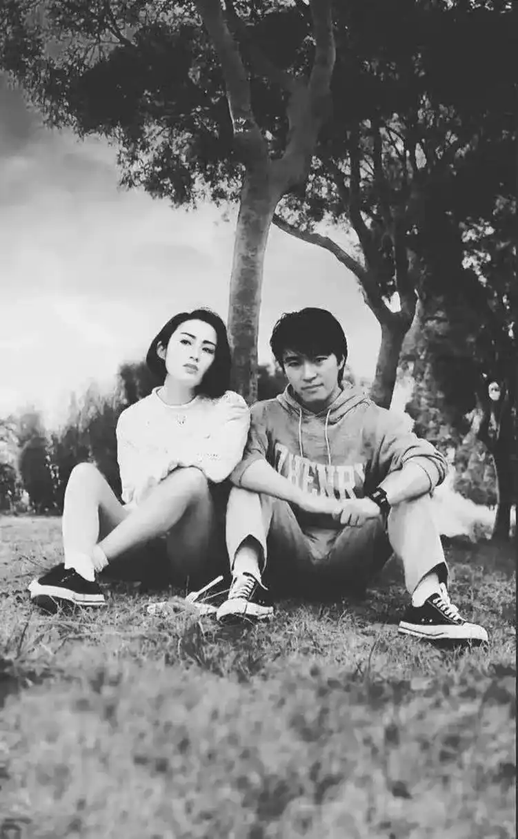 电影场外的草地上,周星驰与张敏身旁笑容满面地坐在一起,留下了一张