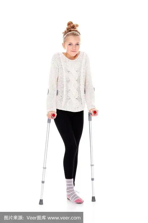 快乐的小女孩,带着脚踝绷带和拐杖