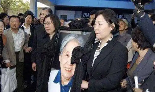 市民们戴着白色的胸花,手里拿着王光美同志的照片,自觉排队进入灵堂