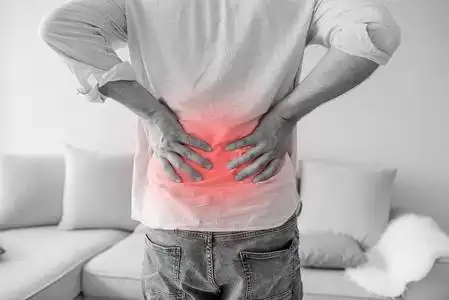 特写一个男人抱着他的背在痛苦单色照片,红色作为硬化的象征.