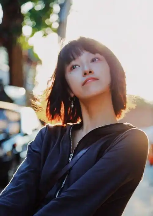 短发造型的艾佳妮有点假小子的意思,一件灰色的连帽卫衣打扮休闲舒适