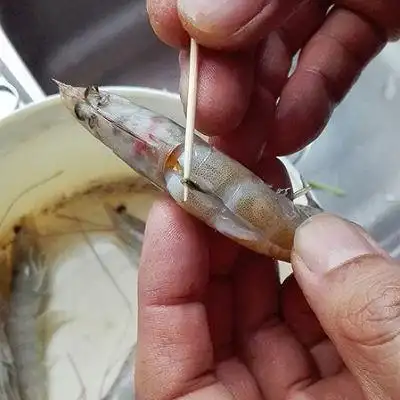 3.大虾用剪子在虾背与虾头的地方剪开,便于压出虾脑,顺道剔除虾线