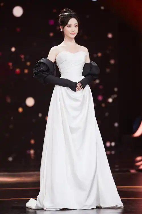 法国梧桐下,@祝绪丹bambi一袭白缎面墨色玫瑰礼服袅袅摇曳,漾开一抹