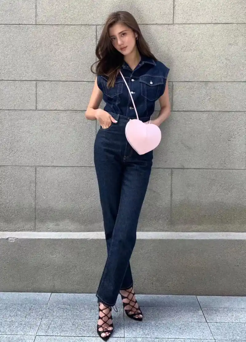 吴千语倚靠在墙边摆pose,她的粉色心形包包很亮眼,鞋子更是时尚感满满