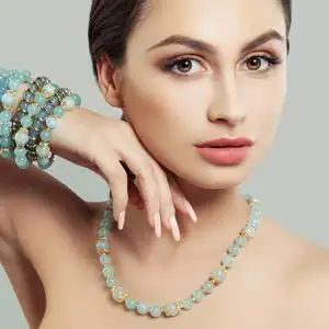 优雅的时装模特女人在首饰项链和手镯与蓝色宝石.