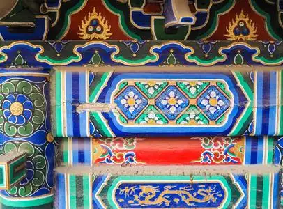 在一座中国寺庙中,充满活力的彩绘屋顶和横梁呈红色,蓝色和绿色照片