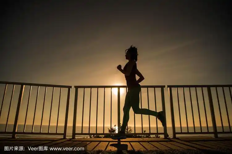 年轻女子在夕阳下奔跑的剪影