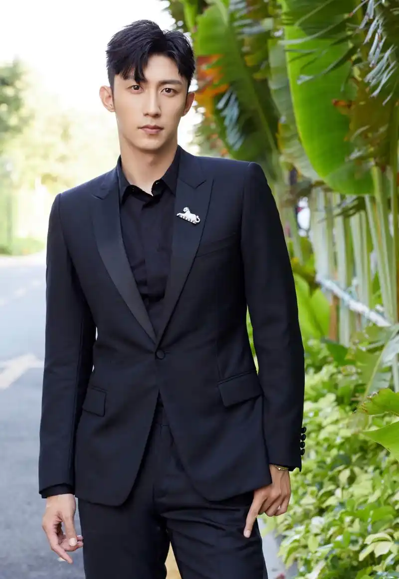 新生代男演员黄景瑜身着一袭黑色套装,逗号刘海搭配金丝眼镜,复古气质