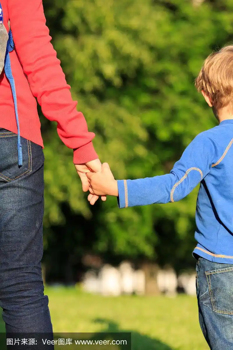 母亲在户外牵着儿子的手