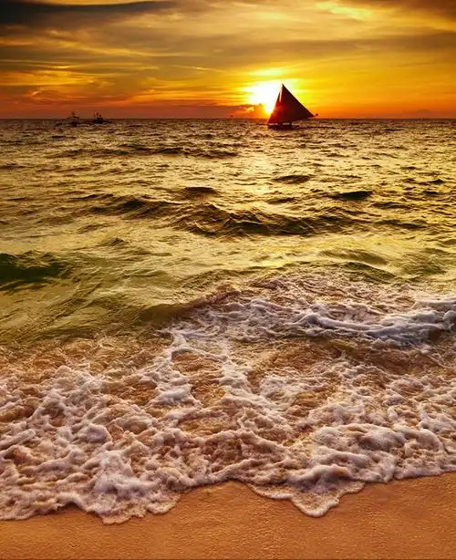 夕阳下的海景和帆船高清摄影图片