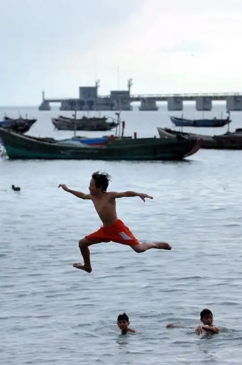 海口市新海渔村的孩子们在海边戏水,以自己独特的方式庆祝儿童节
