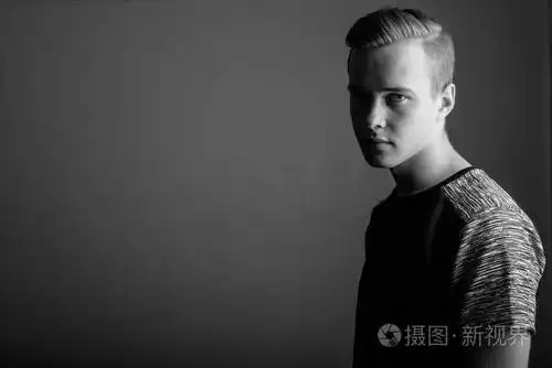 年轻英俊的人在灰色背景在黑色和白色