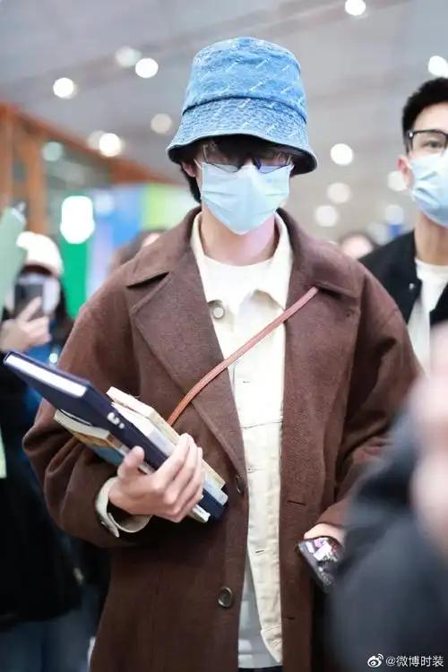 【张新成文艺感穿搭】@张新成机场私服,棕色长款大衣搭配牛仔渔夫帽