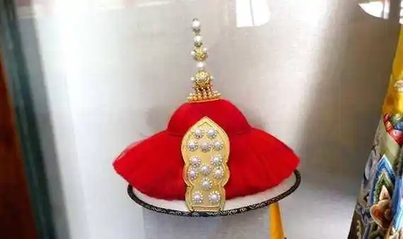 三,"朝冠,冬用薰貂,青狐惟其时.上缀朱纬.