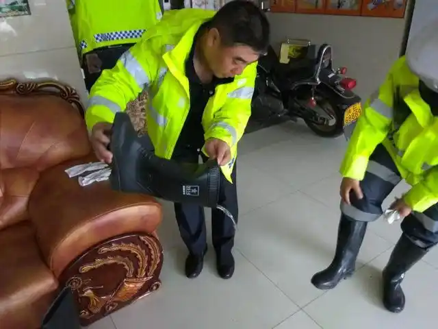 民警正在处理灌满雨靴的雨水